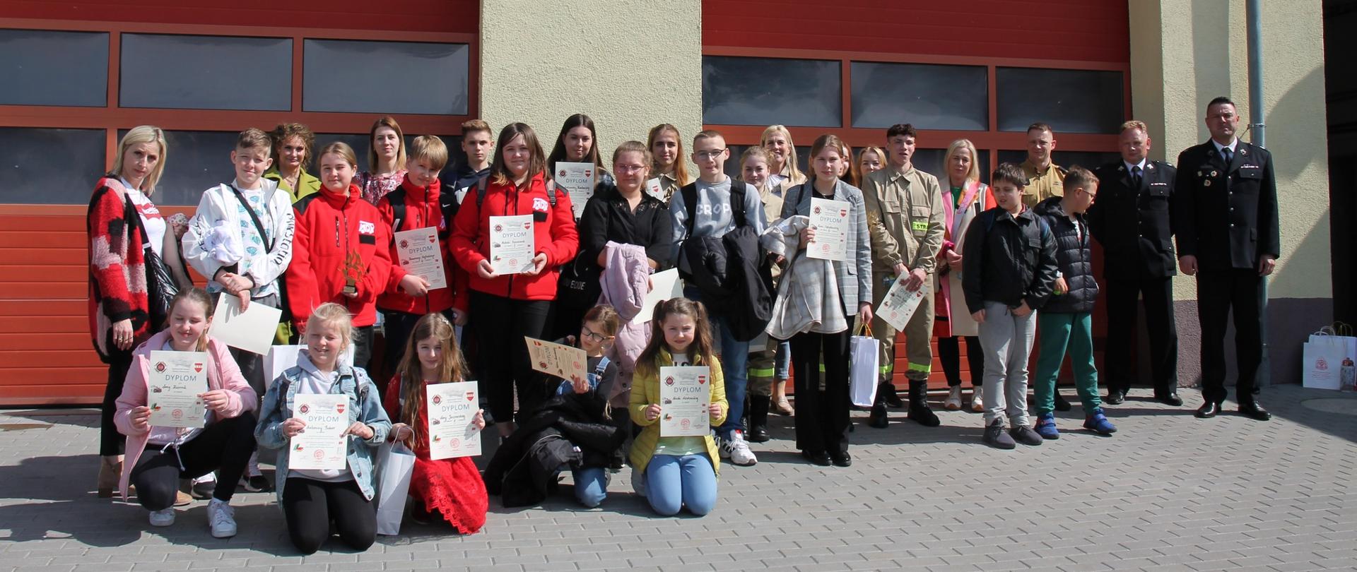 Uczestnicy OTWP 2023 stojący przed bramami wyjazdowymi na placu wewnętrznym JRG Sztum