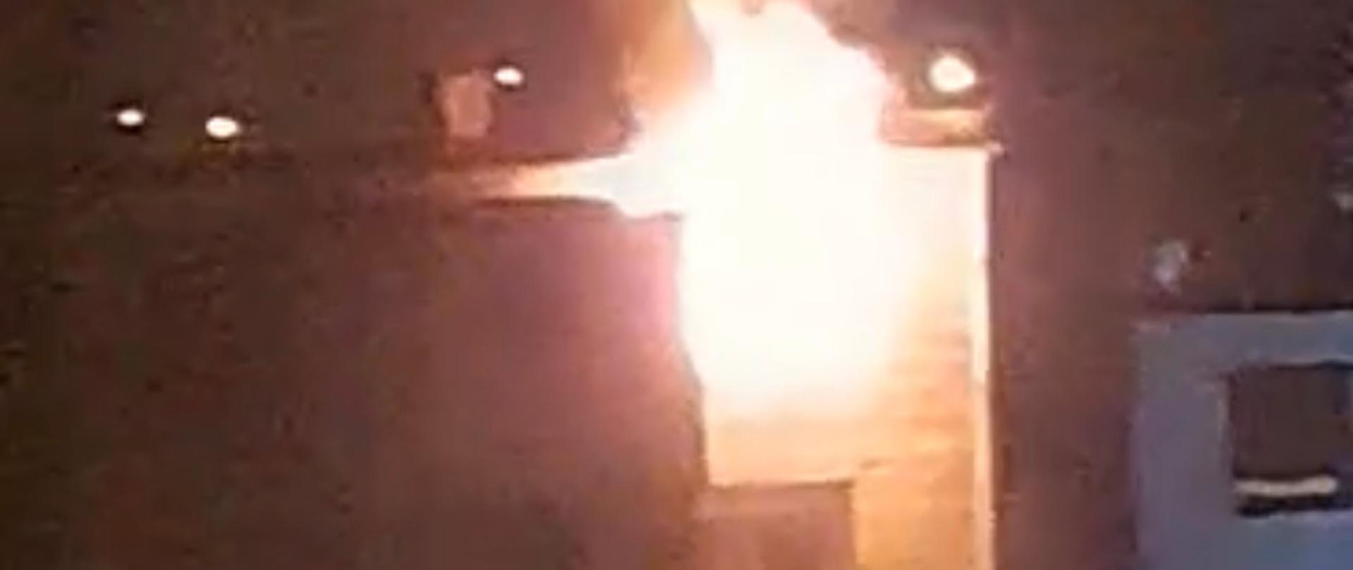 Płomienie wydostają się przez okno na piętrze budynku mieszkalnego