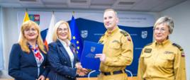Na zdjęciu strażacy oraz przedstawiciele władz wymieniają uścisk dłoni po podpisaniu umowy