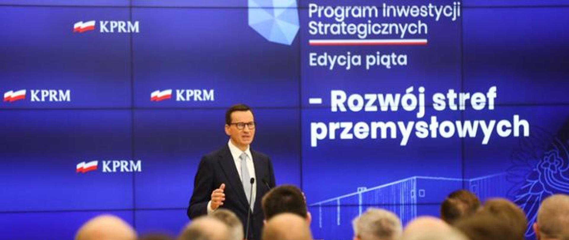 Jeden mężczyzna stojący przed mównicą i wypowiadający się