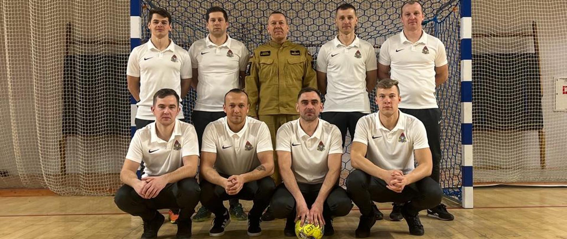 Zwycięstwo sokołowskich strażaków w eliminacjach do „XXI Mistrzostw Województwa Mazowieckiego Strażaków w Halowej Piłce Nożnej” - wspólne zdjęcie w tle bramka