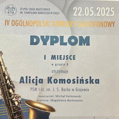 Zdjęcie dyplomu przyznanego Alicji Komosińskiej za zajęcie I miejsca w grupie A podczas IV Ogólnopolskiego Konkursu Saksofonowego, który odbył się 22 maja 2025 roku w Zespole Szkół Muzycznych im. Stanisława Moniuszki w Łodzi. Na dyplomie znajdują się dane szkoły uczennicy: PSM I st. im. J. S. Bacha w Grajewie, a także imiona nauczyciela – Michał Kalinowski i pianistki – Magdalena Borkowska.W tle dyplomu widoczny jest ozdobny motyw z saksofonem na niebieskim kole z cienkimi złotymi liniami.
