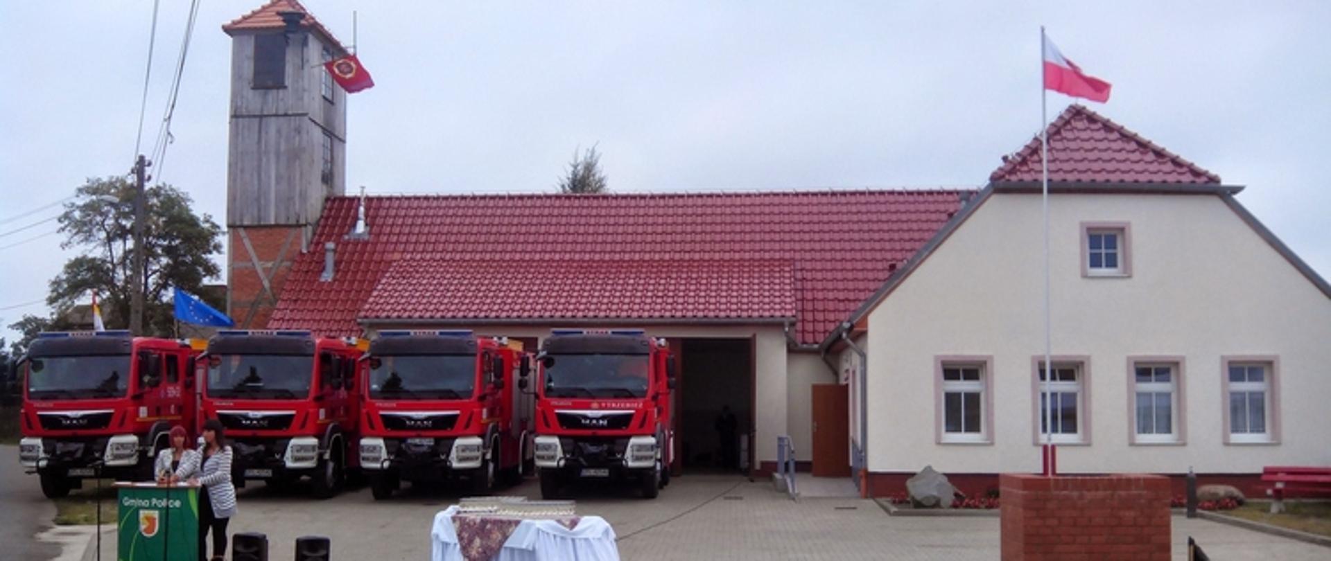 Zdjęcie przedstawia samochody pożarnicze na placu przed strażnicą