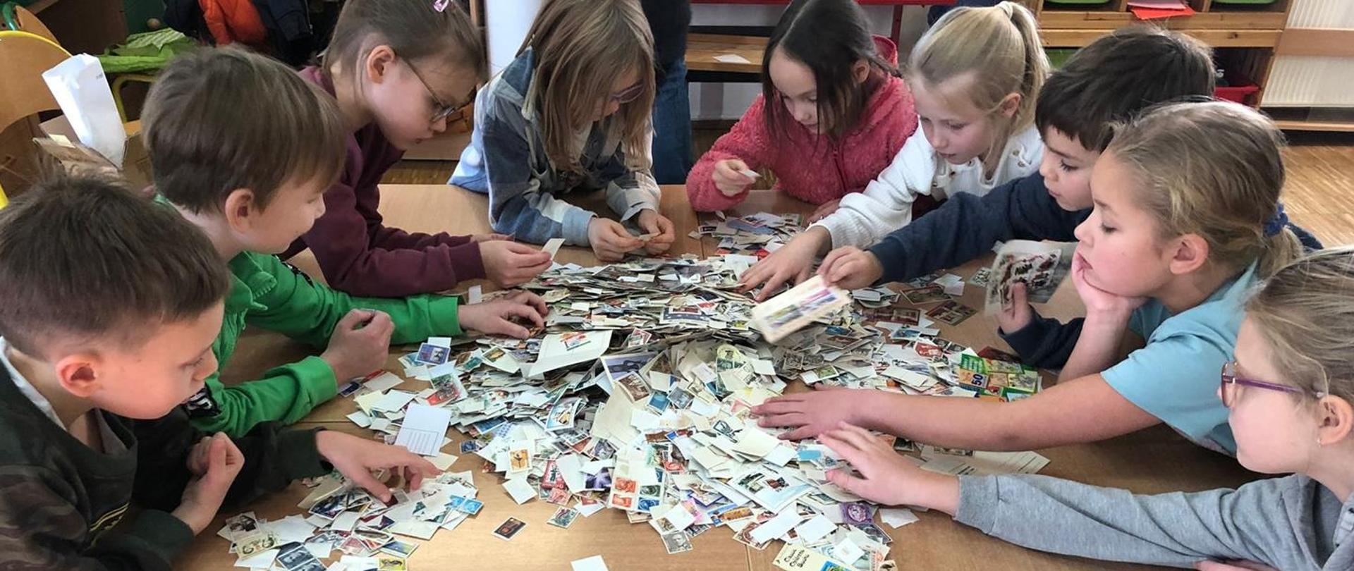 Dzieci oglądają znaczki pocztowe