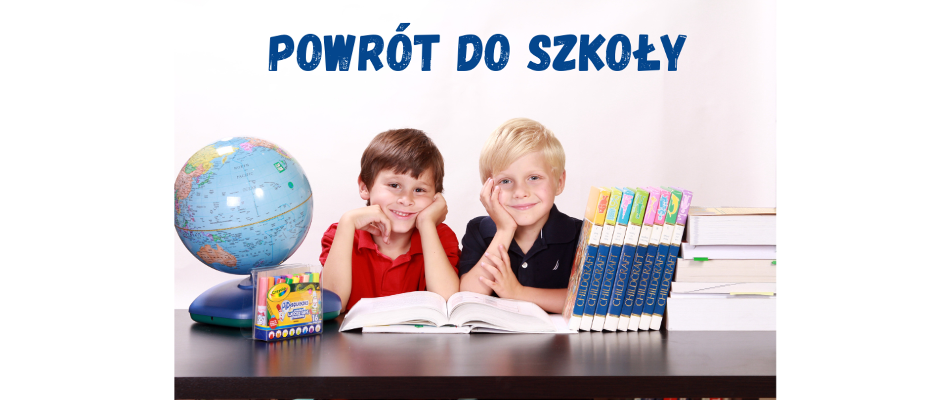 Dwóch chłopców siedzących przy biurku na którym stoją książki i globus.
