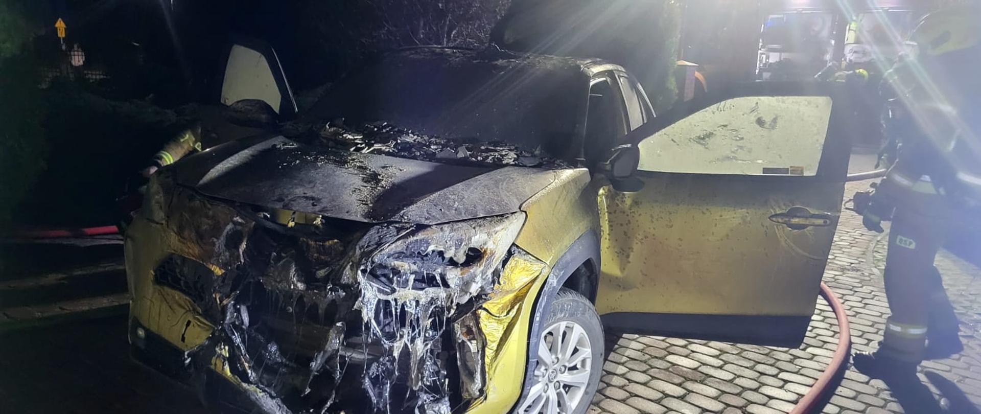 Samochód przed garażem, uszkodzony przód, ciemno