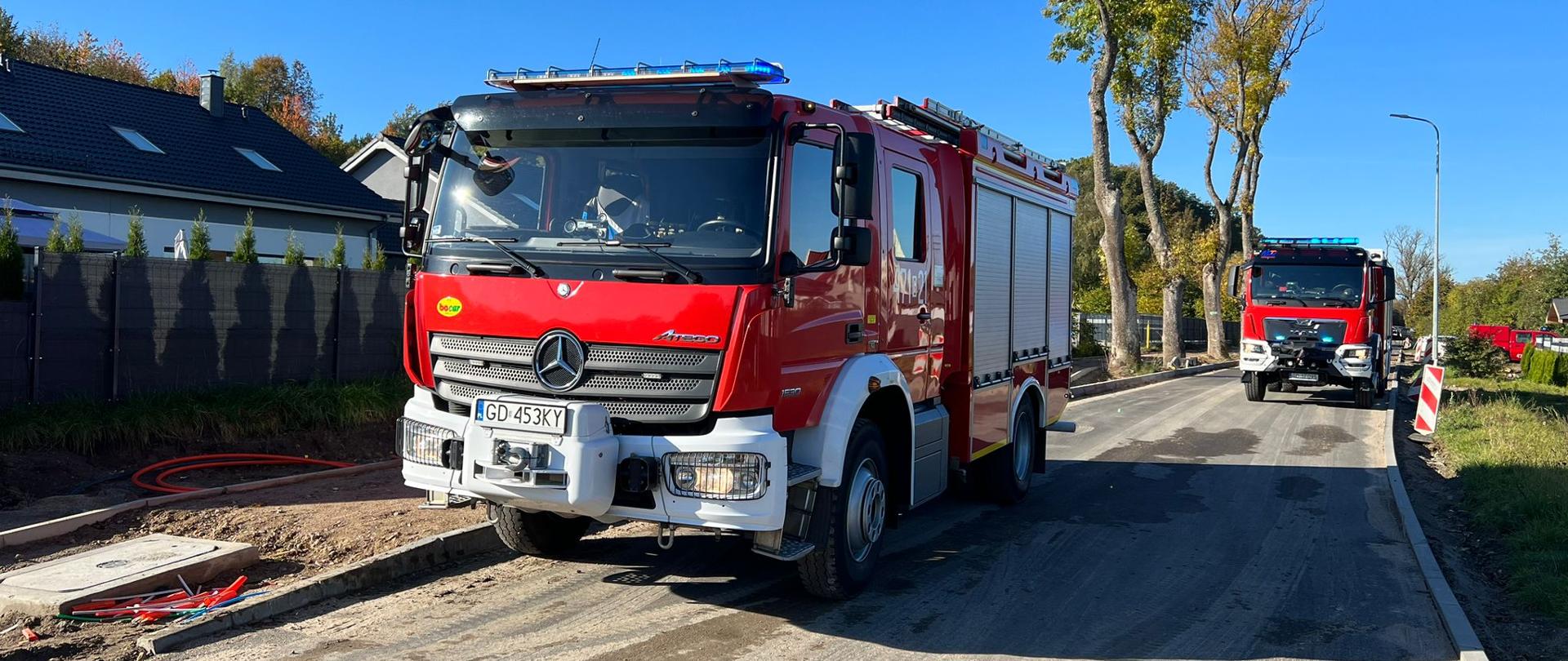 Zdjęcie przedstawia pojazdy pożarnicze ustawione na jezdni zabezpieczające miejsce zdarzenia.