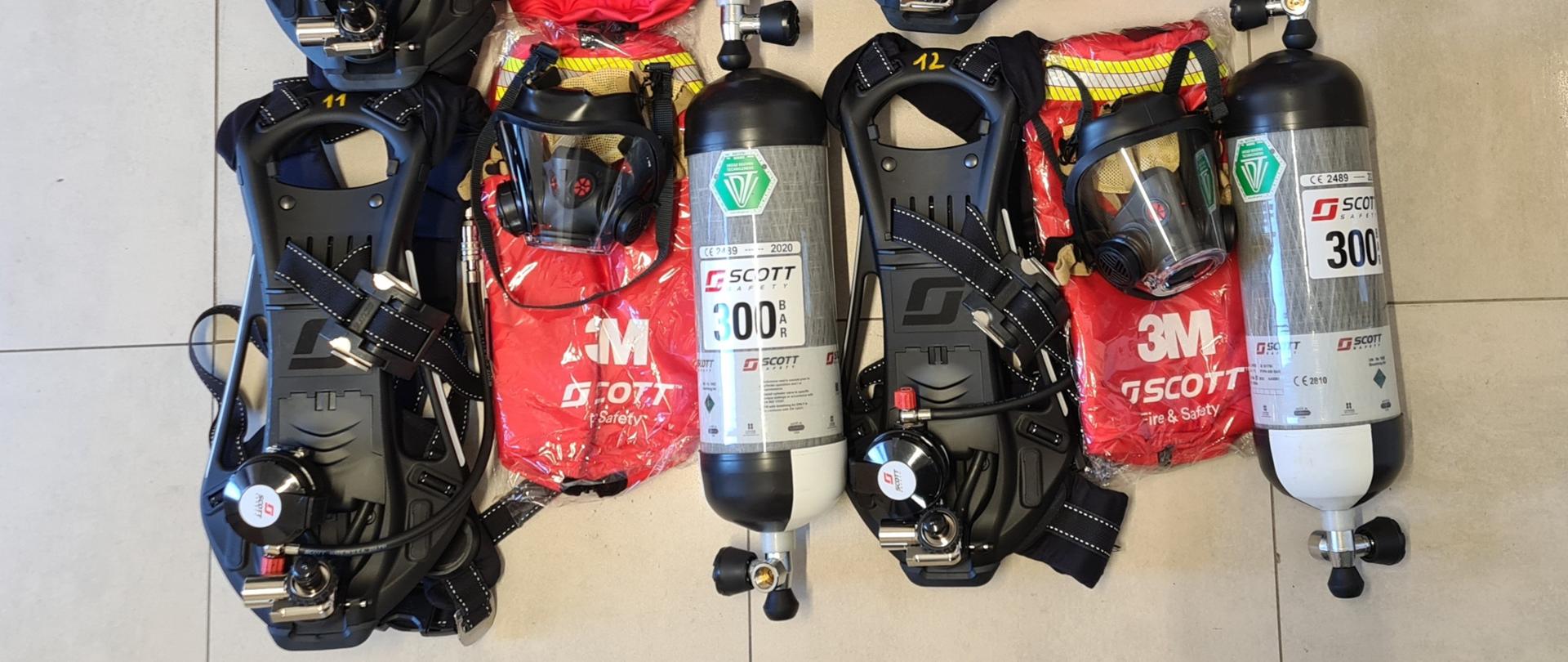 Obraz przedstawia cztery komplety aparatów ochrony dróg oddechowych