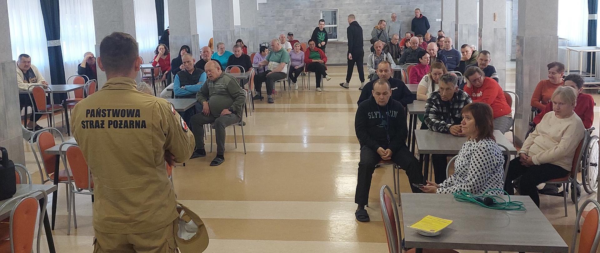 Funkcjonariusz w trakcie spotkania w DPS