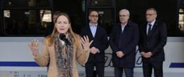 Na zdjęciu minister Katarzyna Pełczyńska-Nałęcz stoi na peronie przed mikrofonem, w tle inni uczestnicy spotkania