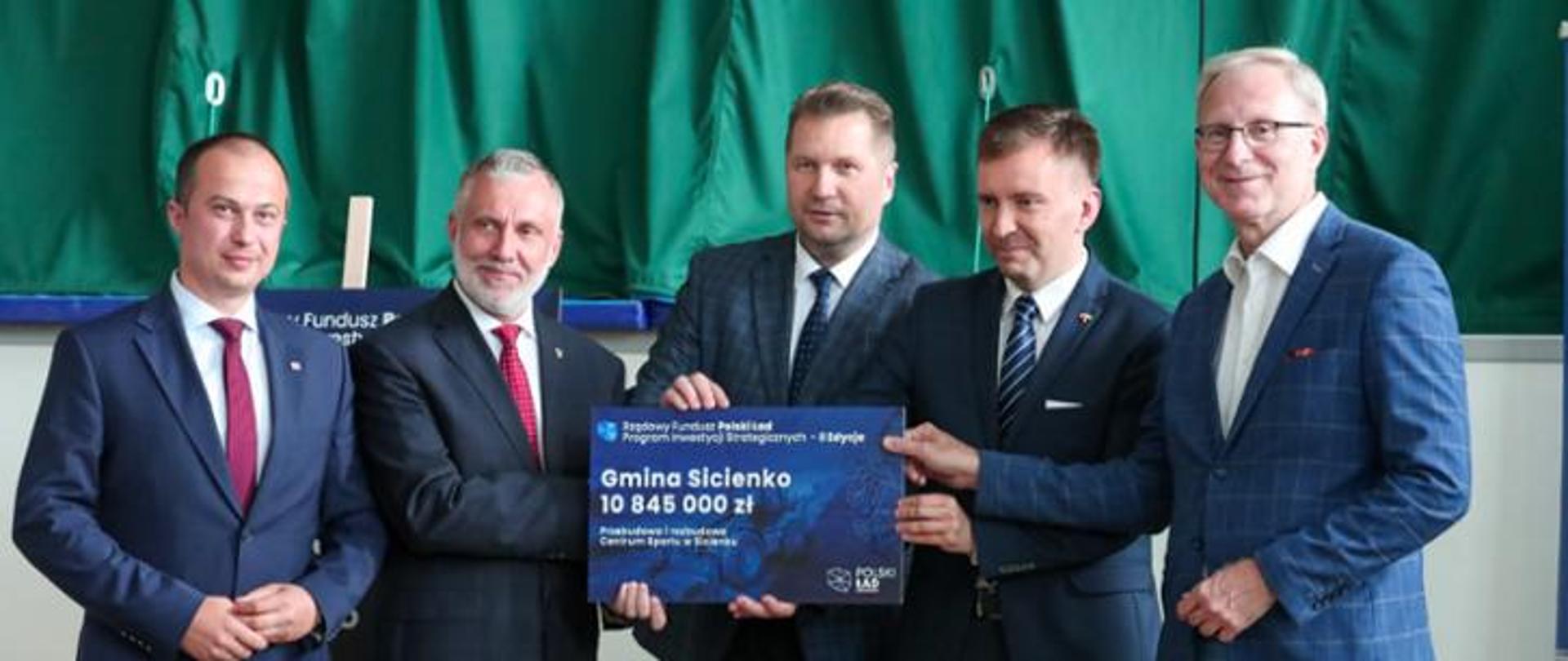 Pięciu mężczyzn stojących z voucherem