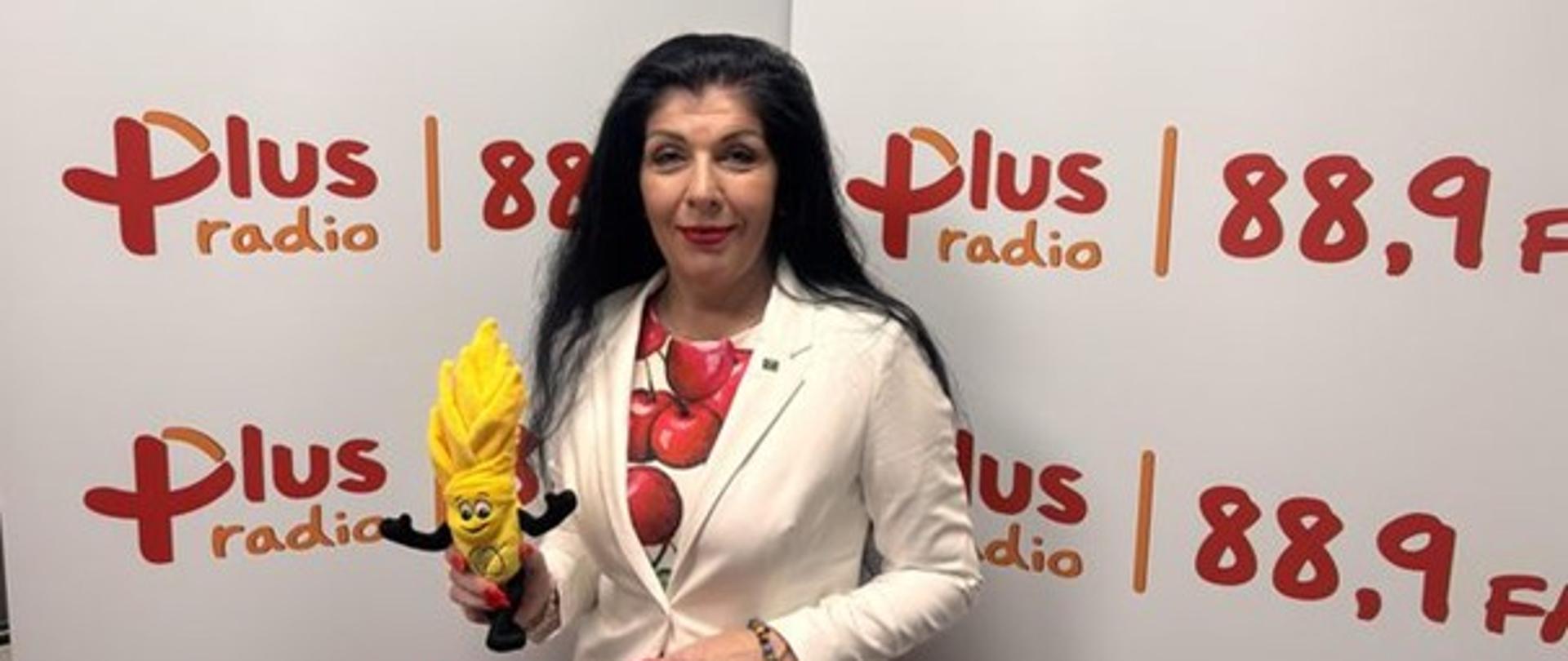 Anna Kusy-Łowicka w studiu Radia Plus trzymająca w ręku maskotkę IJHARS – pluszowego inspektora jakości