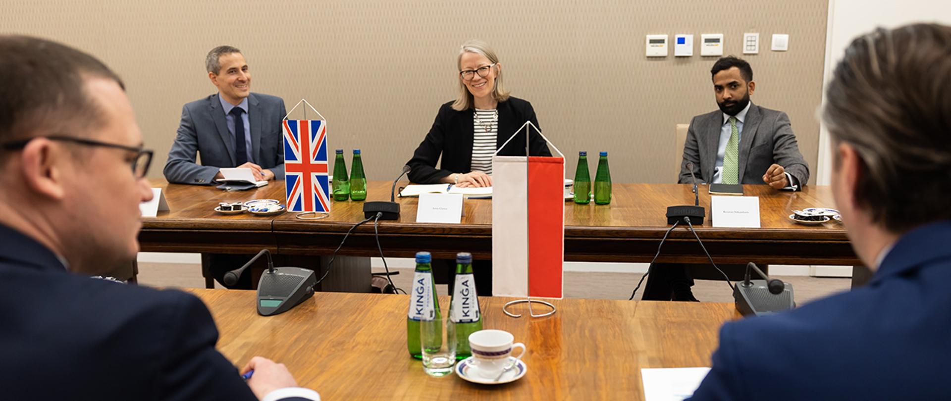 Na zdjęciu widać uczestników spotkania siedzących za stołem.