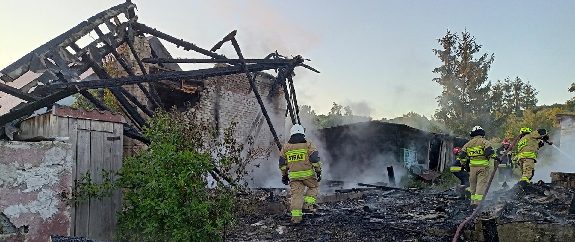 Strażacy dogaszaj spalone elementy stodoły