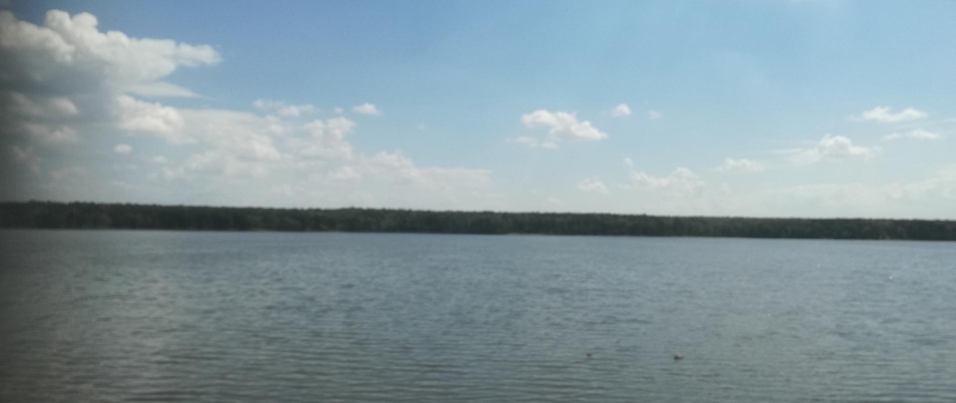 Zalew Zemborzycki. Widok na zbiornik z brzegu. Po drugiej stronie widoczne drzewa.