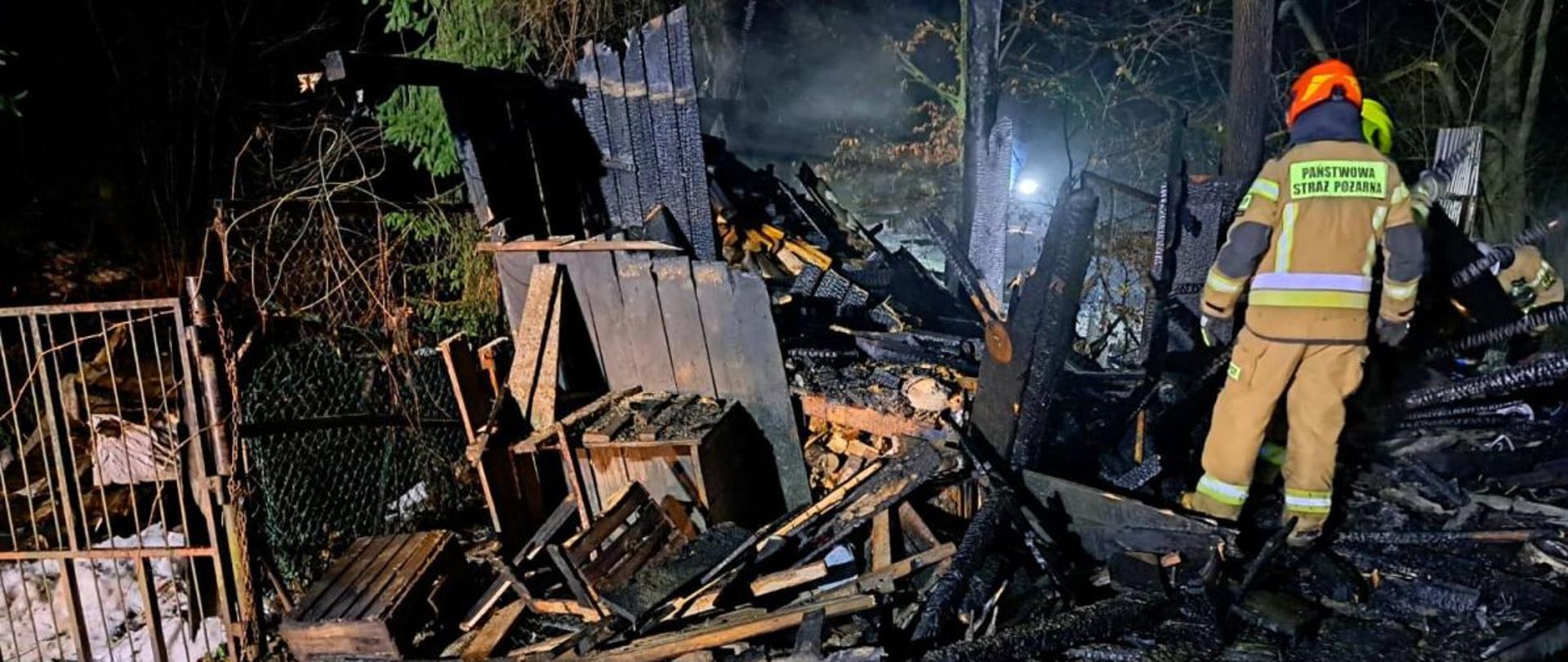 Zdjęcie przedstawia strażaka PSP w miejscu pożaru garażu. 