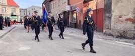 Strażacy w trakcie przemarszu ulicami miasta.