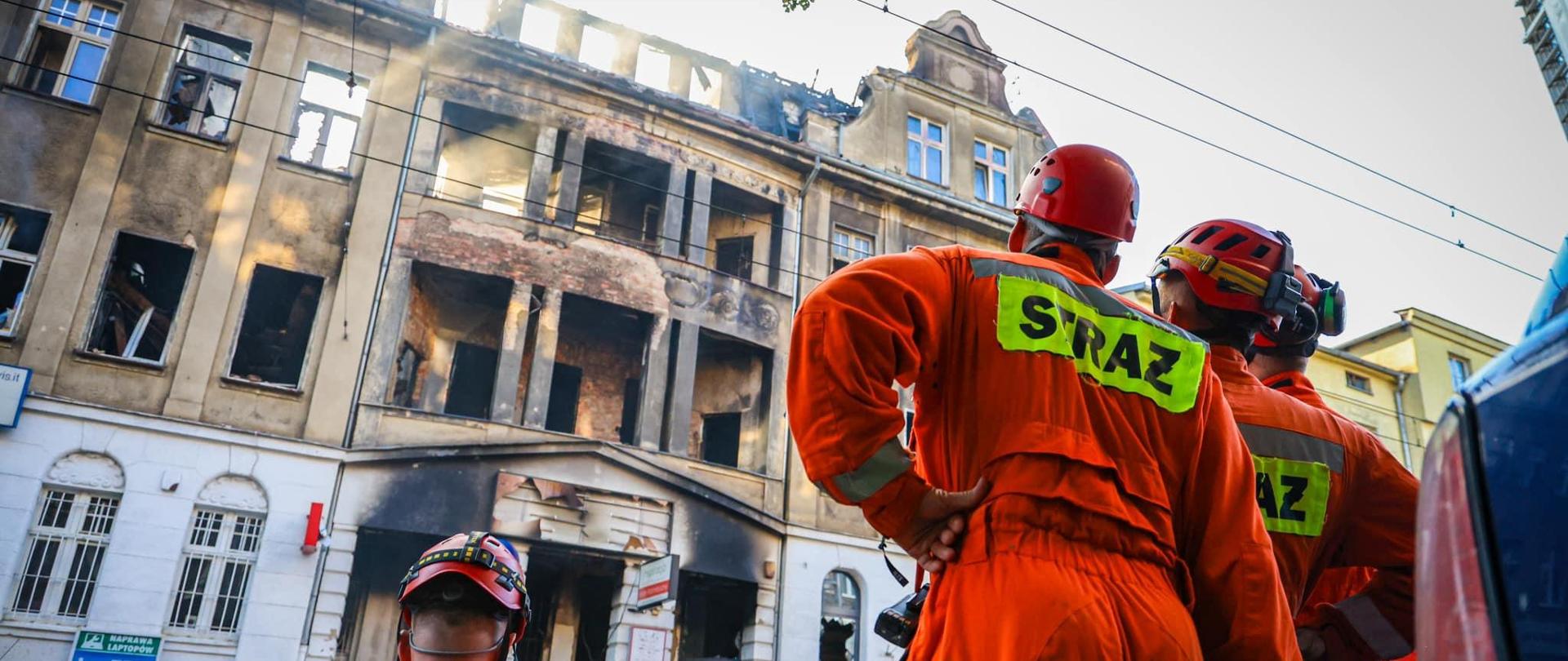 Strażacy z grupy poszukiwawczej analizują parametry budynku po pożarze