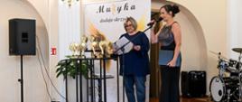 Pani Dyrektor Sonia Wachowska i Wicedyrektor Barbara Kosytorz na scenie w sali koncertowej podczas Koncertu „W odcieniach szmaragdu” wpisującego się w szmaragdowy Jubileusz lublinieckiej szkoły muzycznej