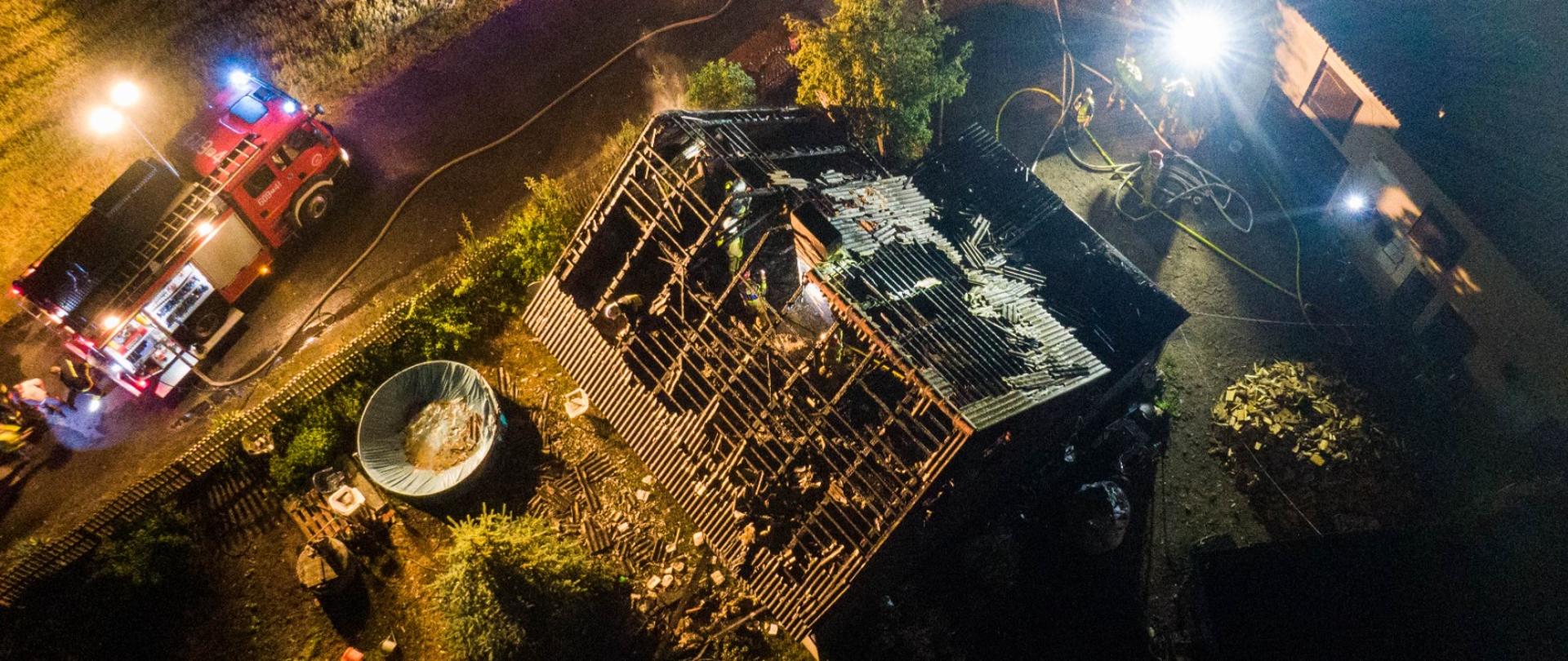 Zdjęcie z drona pokazuje samochód pożarniczy i widok poddasza spalonego 