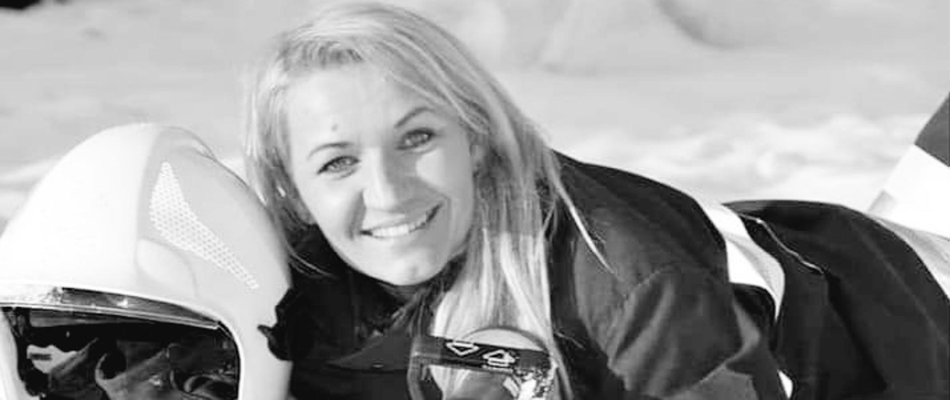 Druhna OSP pozująca do zdjęcia z hełmem i prądownicą w rękach