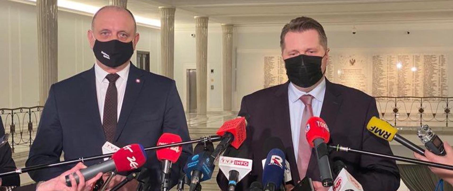 Konferencja ministra Przemysława Czarnka na temat nauki zdalnej, minister Przemysław Czarnek oraz Główny Inspektor Sanitarny Krzysztof Saczka stoją w Selmie przed mikrofonami podczas konferencji.