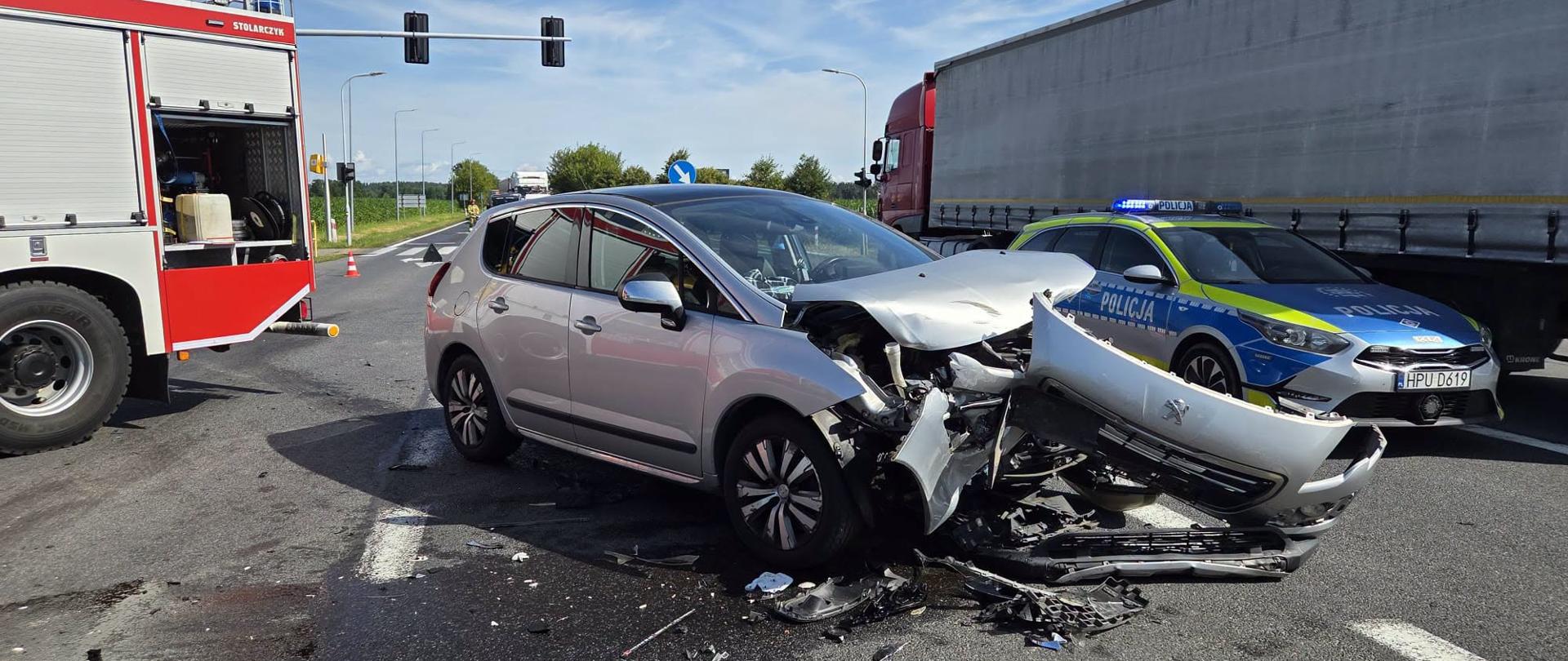 Zdjęcie przedstawia strażaków podczas zdarzenia drogowego na DK-11 w Budzyniu.
W tle jezdnia i pojazdy. 