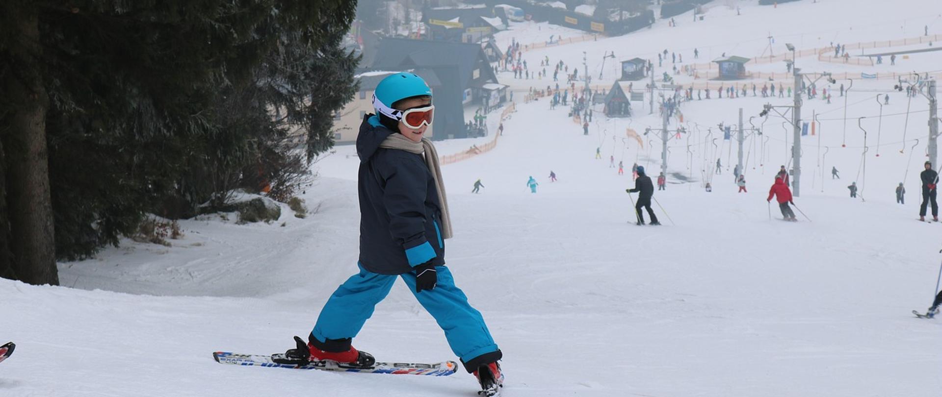 Zdjęcie przedstawiające dziecko zjeżdżające na nartach ze stoku