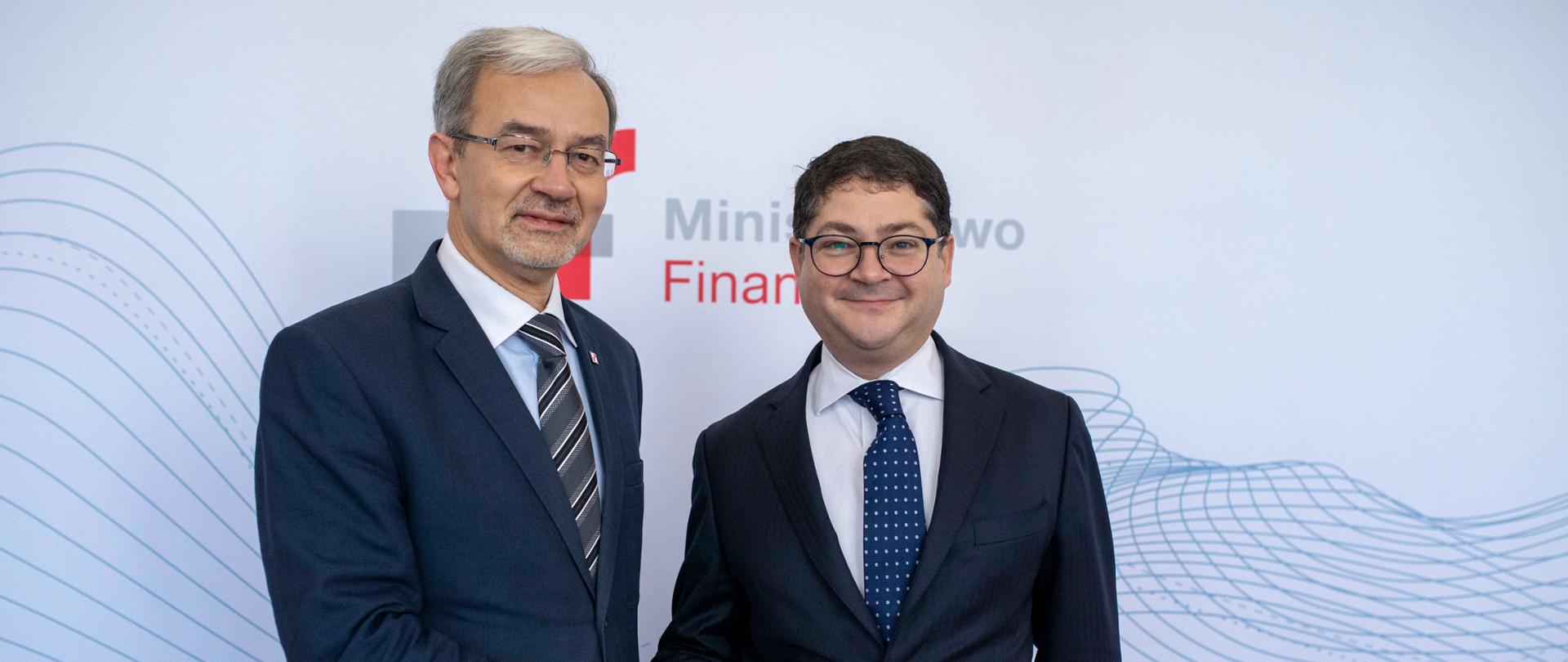 Minister Kwieciński i wiceprezes EBOR Pierr Heilbronn na tle banera Ministerstwa Finansów