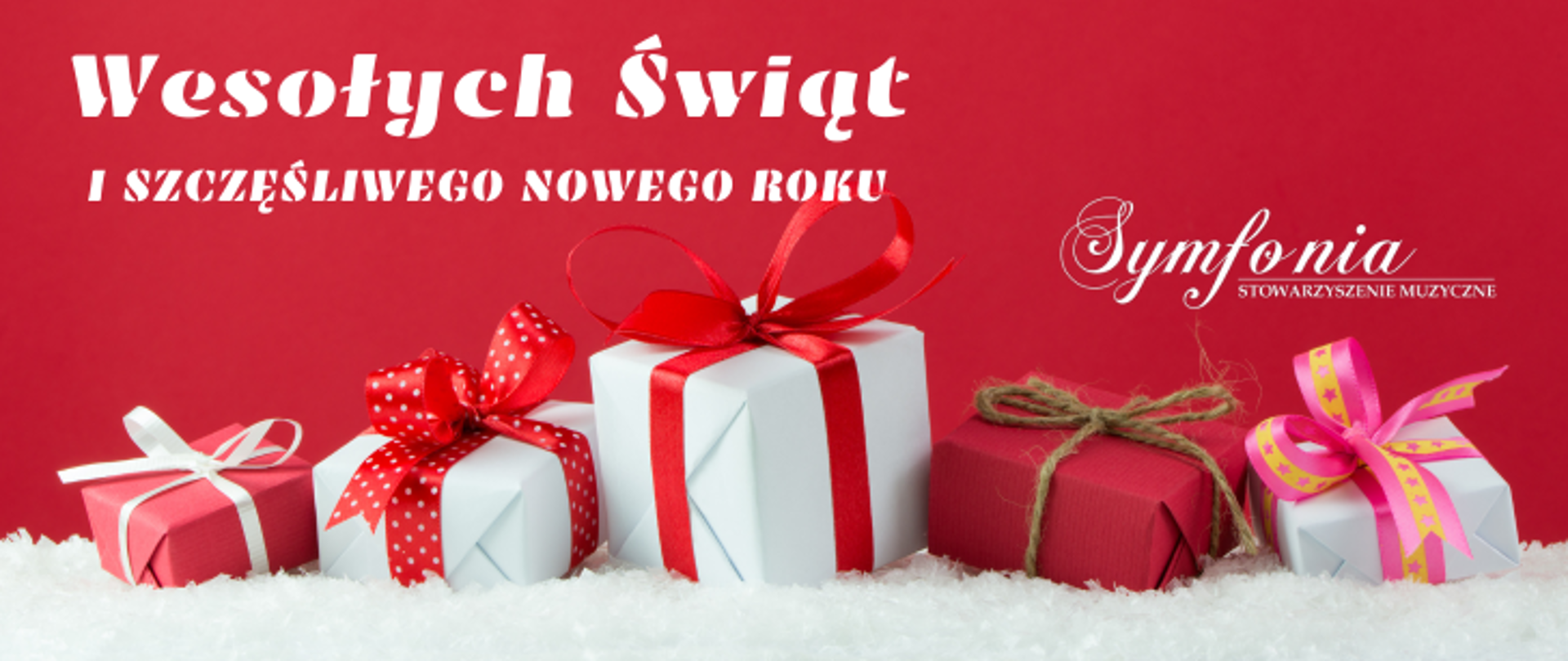 Na czerwonym tle grafika paczek prezentowych a nad nimi napis Wesołych Świąt oraz Szcześliwego Nowego Roku . Po prawej stronie logo Symfonii 