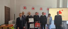 Zdjęcie przedstawia wręczenie nagród KP PSP w Kartuzach podczas finału akcji ognisty ratownik - gorąca krew. Na zdjęciu obecni są przedstawiciele polskiego czerwonego krzyża oraz komendy głównej psp.