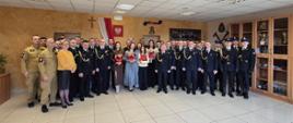 Duże zdjęcie grupowe wszystkich uczestników uroczystości: strażaków w różnych typach umundurowania oraz zaproszonych kobiet.