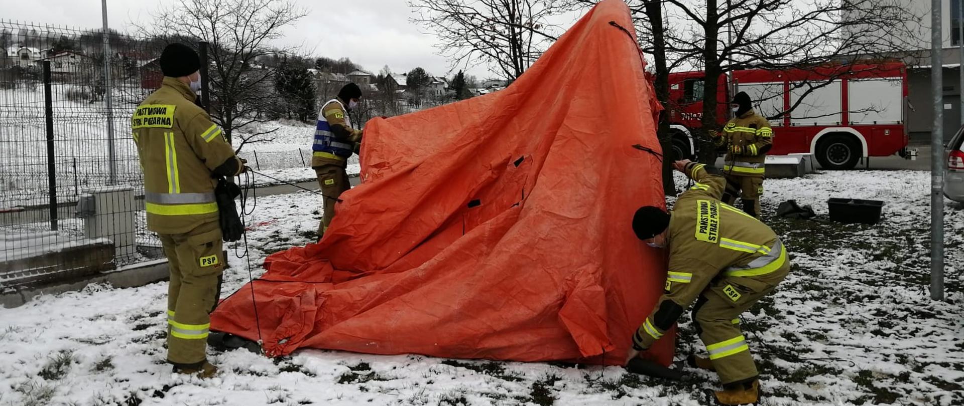 Strażacy rozkładają namiot pneumatyczny przed budynkiem Szpitala Żywiec.