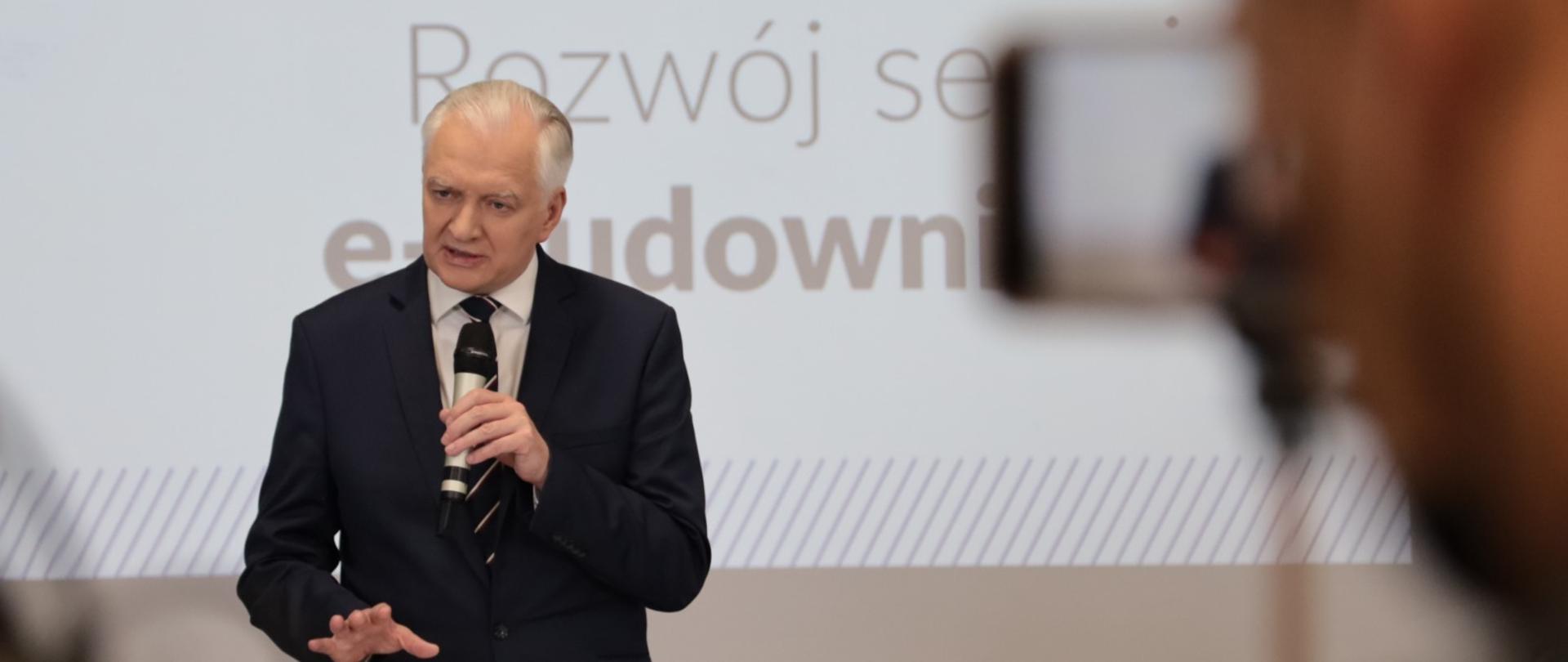 Premier Gowin przemawia na konferencji prasowej o serwisie e-budownictwo.