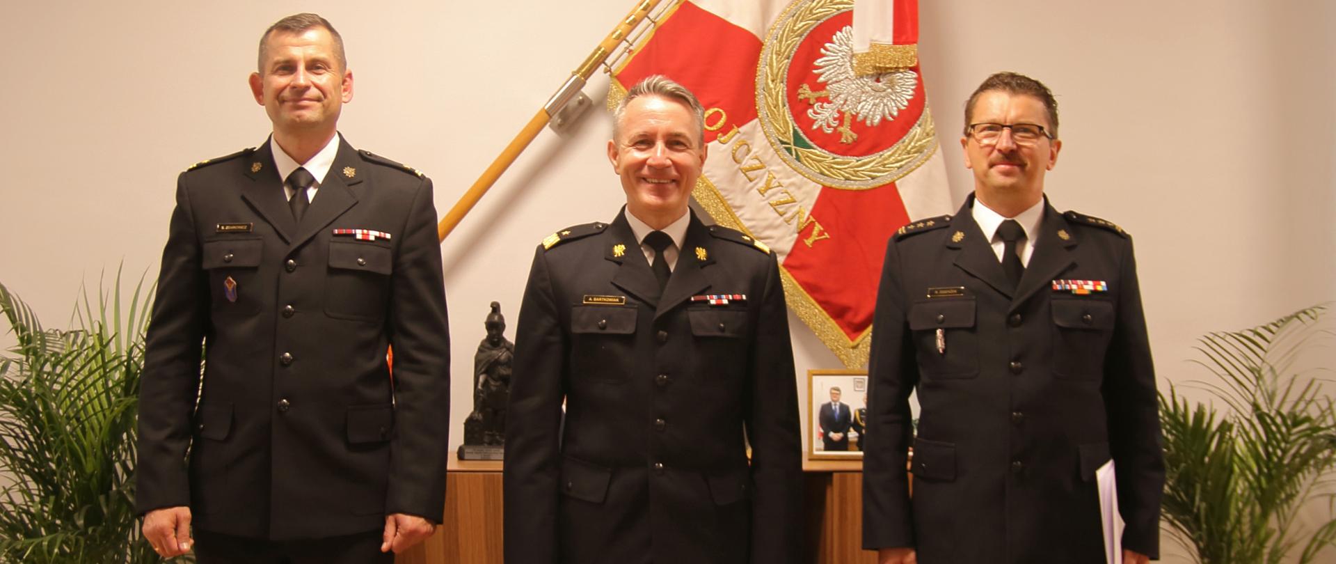 Komunikat kadrowy – na zdjęciu nadbryg. Andrzej Bartkowiak oraz st. bryg. mgr. inż. Robert Dzierżek, oraz podlaski komendant wojewódzki . Zdjęcie na tle sztandaru.