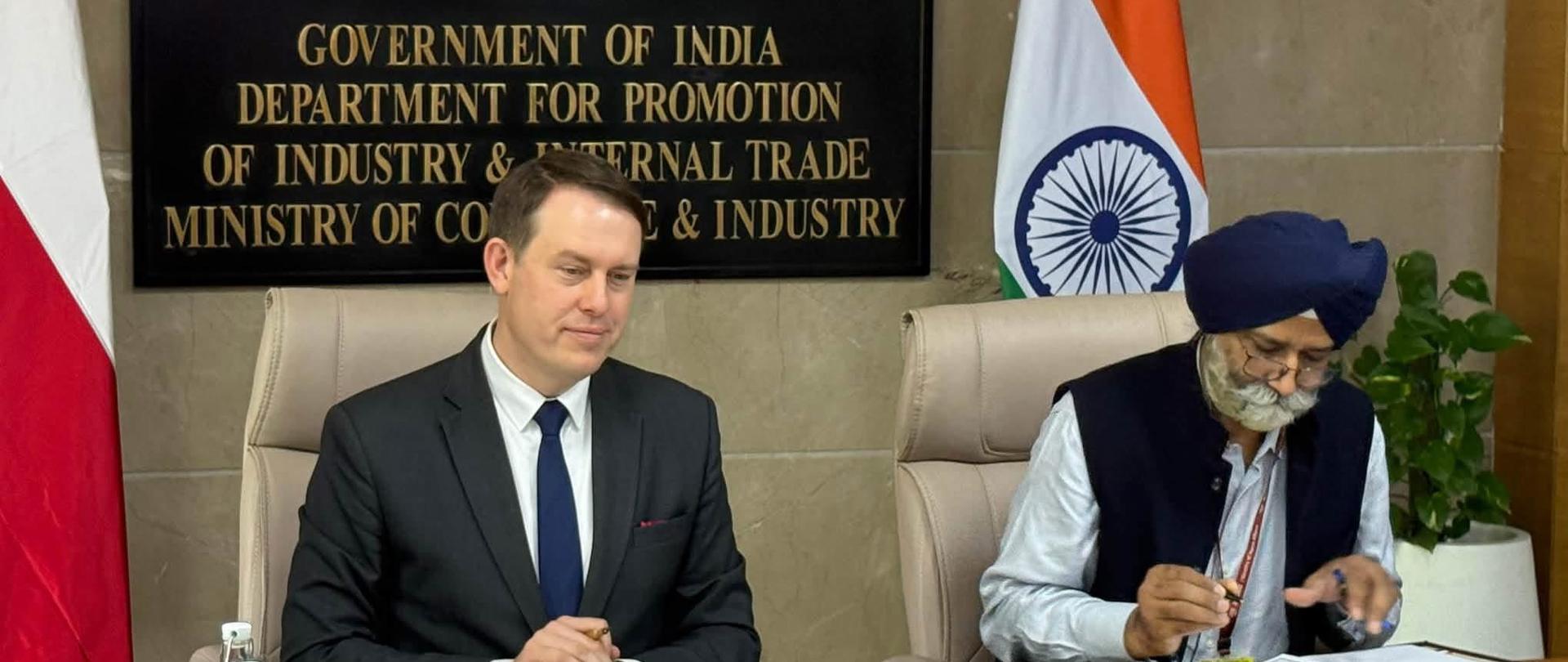 Deputy Minister of Development and Technology Michał Baranowski poses with Indian counterparts following the 7th Session of the India–Poland Joint Commission for Economic Cooperation in New Delhi. The Polish and Indian national flags are displayed behind the participants.