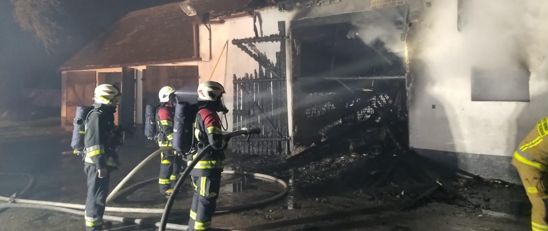 Strażacy w aparatach powietrznych dogaszają pożar