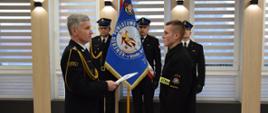 Nowy funkcjonariusz str. Rafał Olko po ślubowaniu, Komendant Powiatowy PSP w Mińsku Mazowieckim przekazuje na jego ręce akt ślubowania i gratulacje oraz życzenia spokojnej służby w szeregach PSP.
