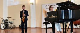 Wykonawcy przy instrumentach na scenie w sali koncertowej podczas Koncertu końcoworocznego wpisującego się w szmaragdowy Jubileusz lublinieckiej szkoły muzycznej