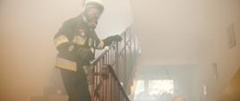 Dwóch strażaków na zadymionej klatce schodowej w aparatach ODO