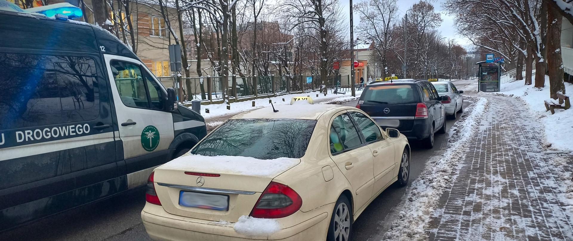 Kremowa taksówka, obok radiowóz ITD