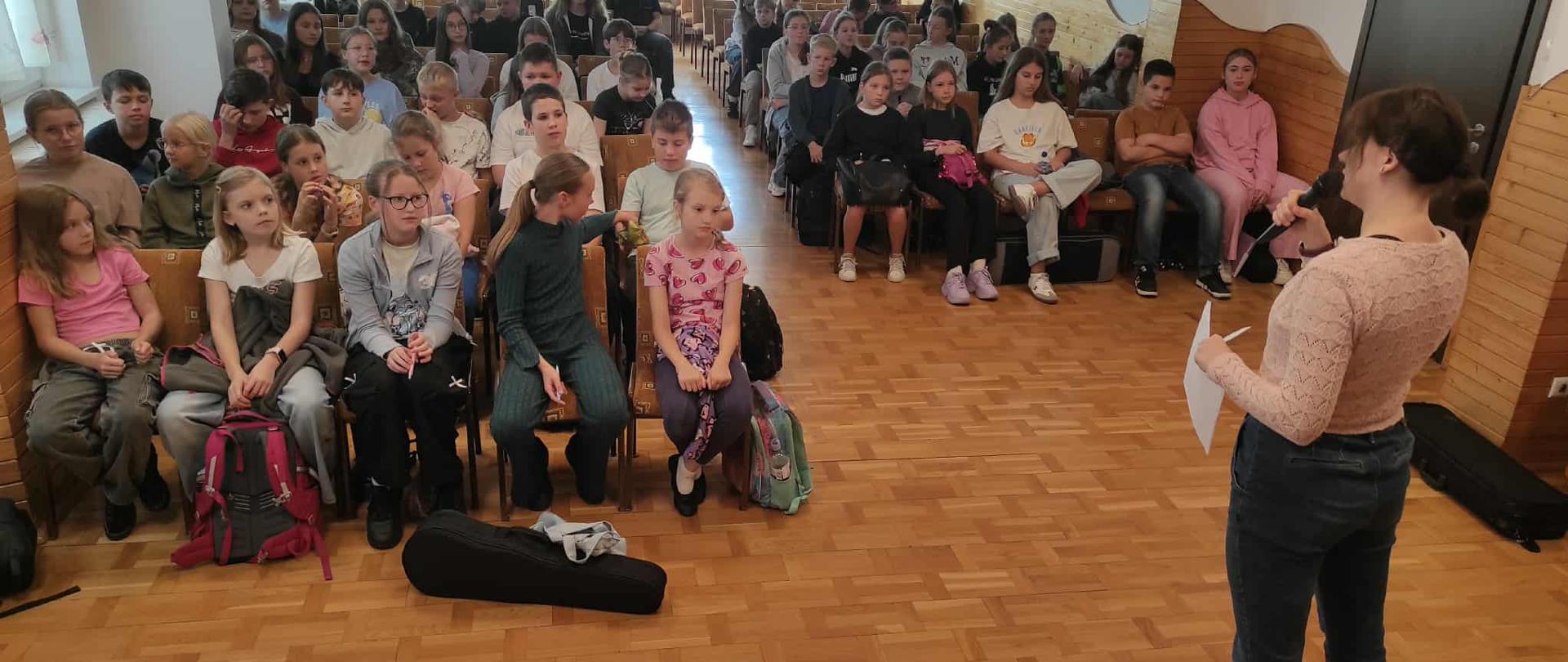 na widowni uczniowie zebrani na lekcji wychowawczej, przed nimi nauczyciel