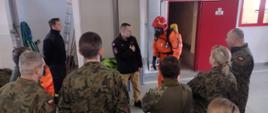 Na zdjęciu widoczni są Funkcjonariusze Państwowej Straży Pożarnej oraz żołnierze z 10 Świętokrzyskiej Brygady Wojsk Obrony Terytorialnej z 102 batalionu lekkiej piechoty podczas omawiania ważności środków ochrony indywidualnej.