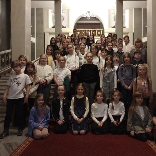 Zbiorowe zdjęcie wycieczkowiczów na schodach w Teatrze Wielkim w Warszawie