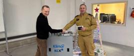 Na zdjęciu Komendant Powiatowy PSP w Pucku bryg. Wojciech Wanat oraz przedstawiciel firmy Klimor- centrale klimatyzacyjne i wentylacyjne. Komendant ubrany w strój służbowy w kolorze piaskowym. 