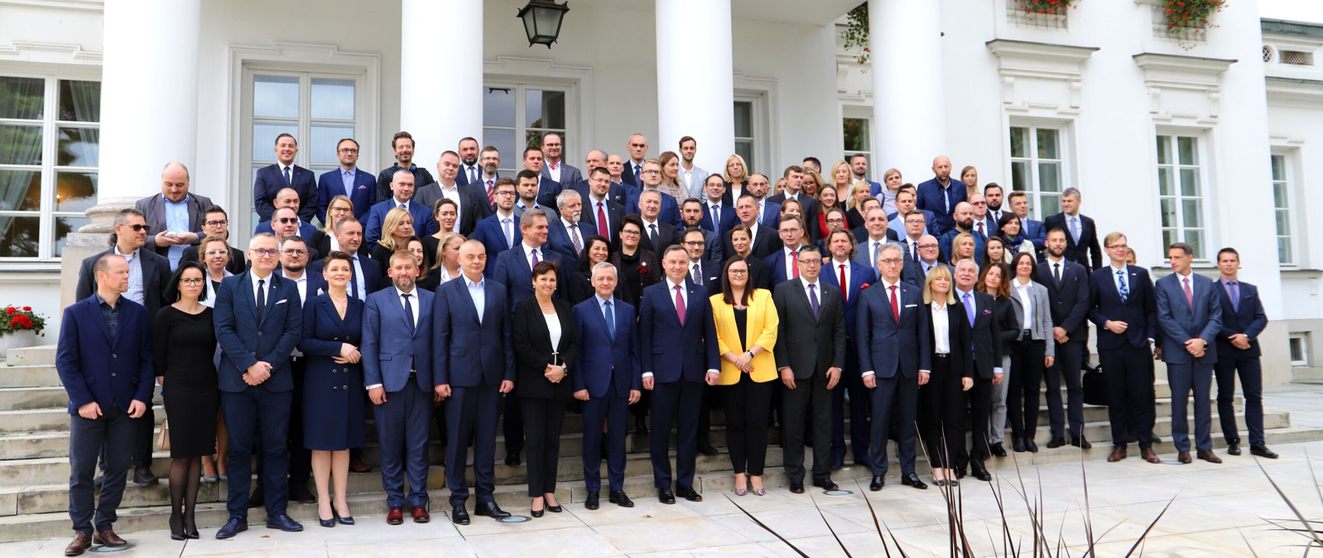 Kilkadziesiąt osób pozujących do zdjęcia przed Belwederem