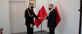 Zdjęcie przedstawia pomorskiego komendanta wojewódzkiego PSP st. bryg. Piotra Sochę wręczającego decyzję o powierzeniu obowiązków zastępcy komendanta powiatowego PSP w Człuchowie bryg. Radosławowi Batruchowi.