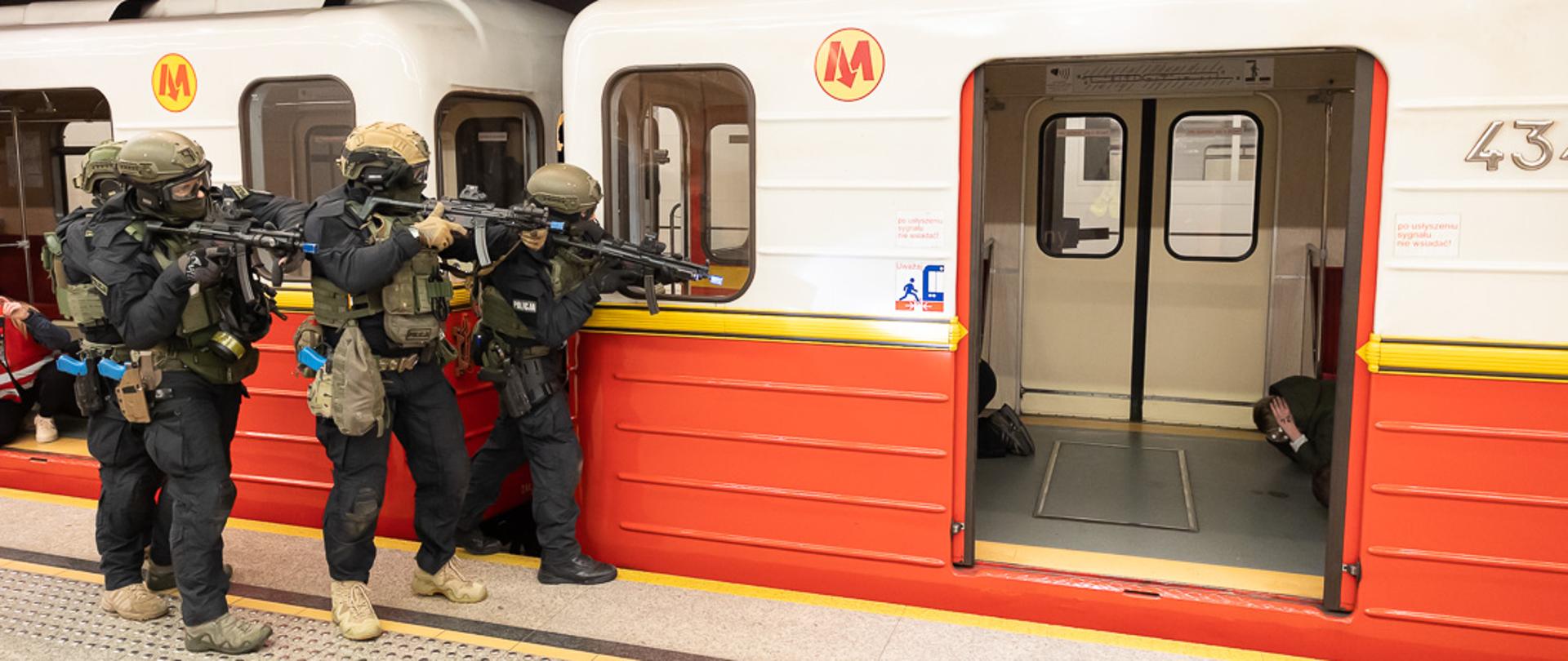 funkcjonariusze z bronią w trakcie ćwiczeń antyterrorystycznych wchodzą do wagonu metra