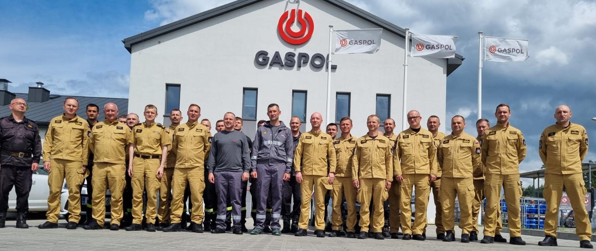 Wszyscy uczestnicy odprawy szkoleniowej na tle budynku Terminala Przeładunkowego Gaspol S.A. w Pawłowicach.