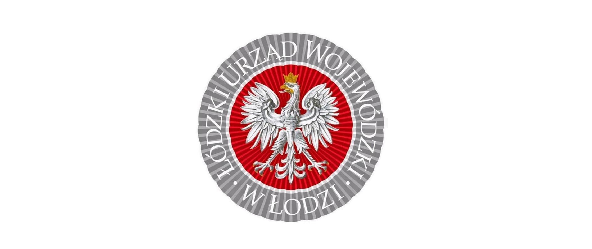 Logo Łódzkiego Urzędu Wojewódzkiego w Łodzi. W środkowej części logo znajduje się orzeł biały w złotej koronie na czerwonym okrągłym tle. Dookoła znajduje się napis na szarym tle Łódzki Urząd Wojewódzki w Łodzi. Litery są w białym kolorze.